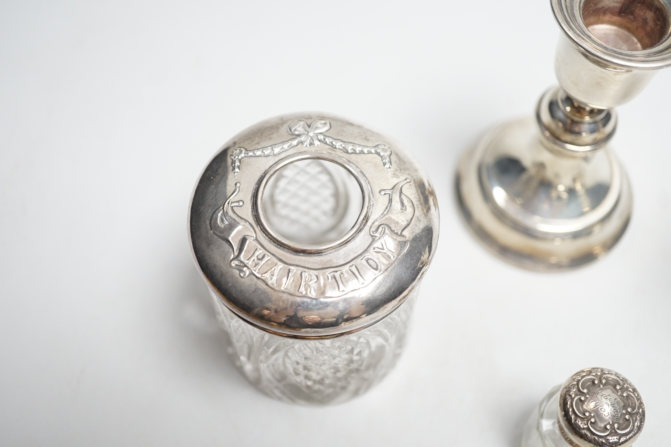 A pair of 1930's silver mounted dwarf candlesticks, 10cm, a silver mounted glass hair tidy and a scent bottle.